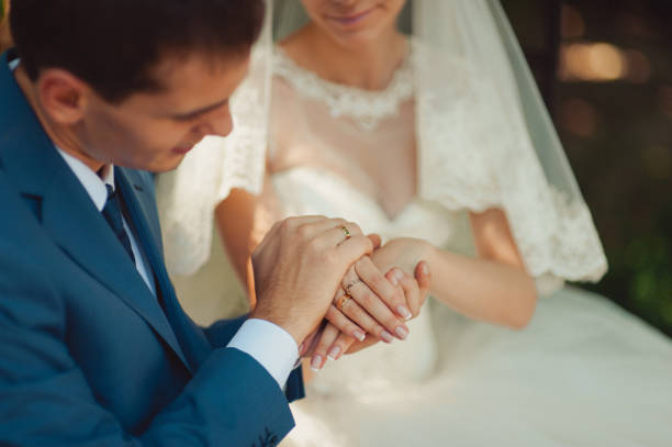 istock Wedding couple holding hands in the park 831364446