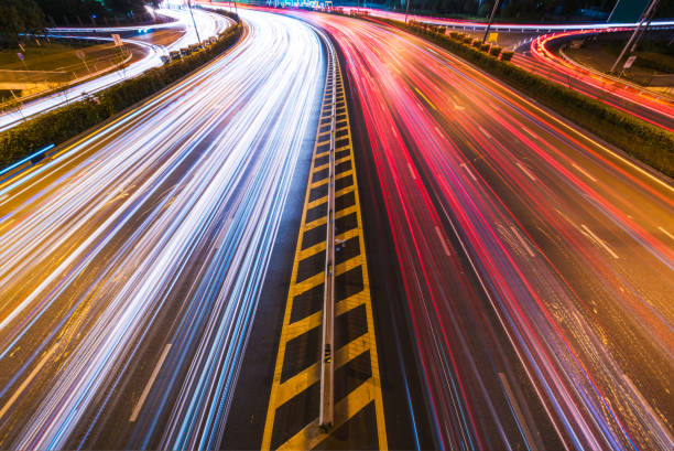 istock Cars light trails on a curved highway at night 831364592