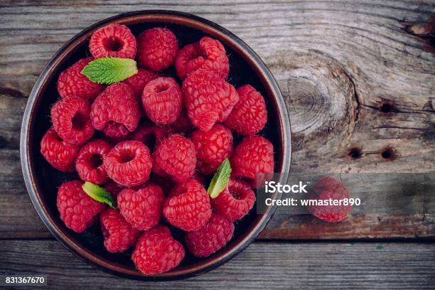 Fresh Ripe Organic Raspberry In A Plate On A Wooden Background Stock Photo - Download Image Now