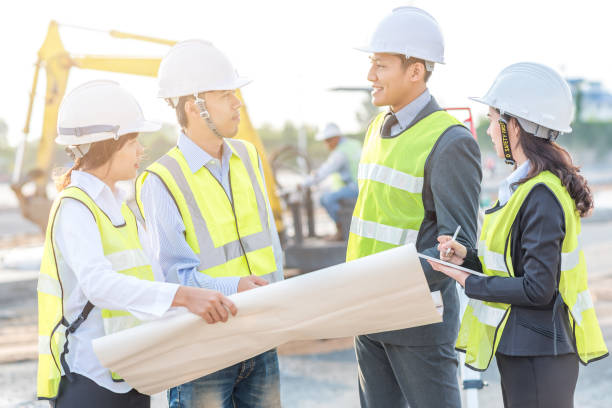 istock Engineer and builder review blueprint during team meeting 831368610