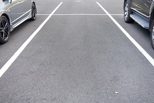 space between cars in asphalt parking lot