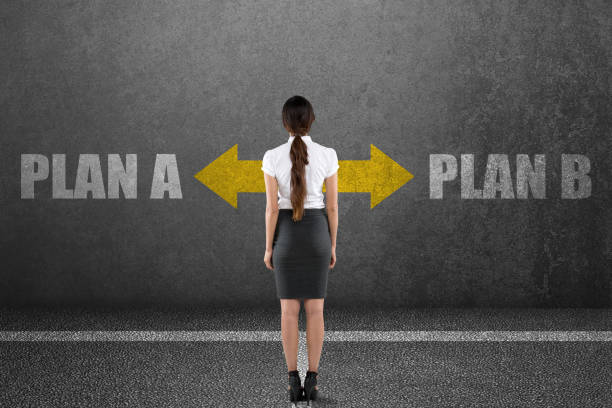 istock Businesswoman with plan a and plan b choice on wall 831372778