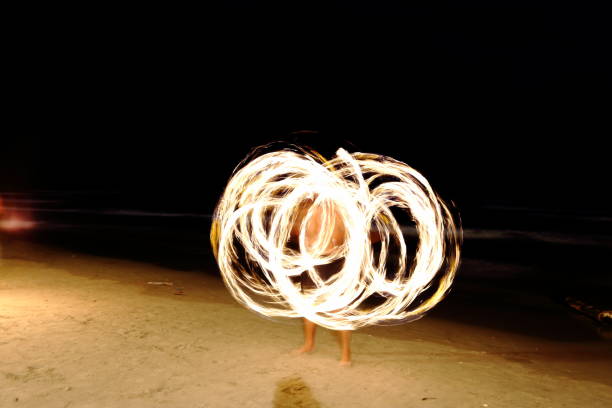 istock Skill Man playing fireworks by spinning wood pole with fuel oil and fire 831372818