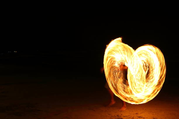 istock Skill Man playing fireworks by spinning wood pole with fuel oil and fire 831374928