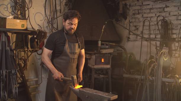 istock Man works with molten metal in the forge 831375428