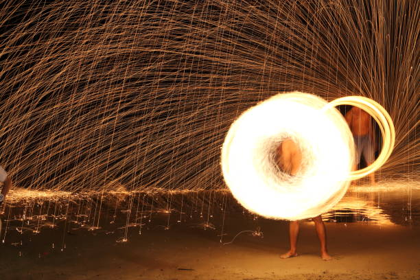 istock Skill Man playing fireworks by spinning wood pole with fuel oil and fire 831375438