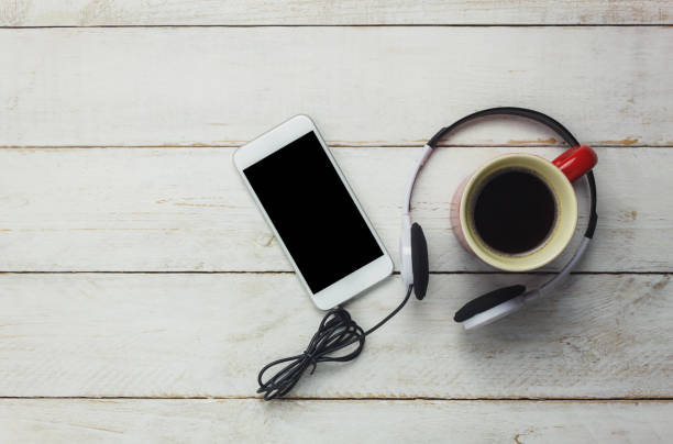 istock Table top of the technology and music background concept.Mix object and coffee drink on modern rustic white wooden background. Empty space for free text or word creative design. Overhead view. 831378962