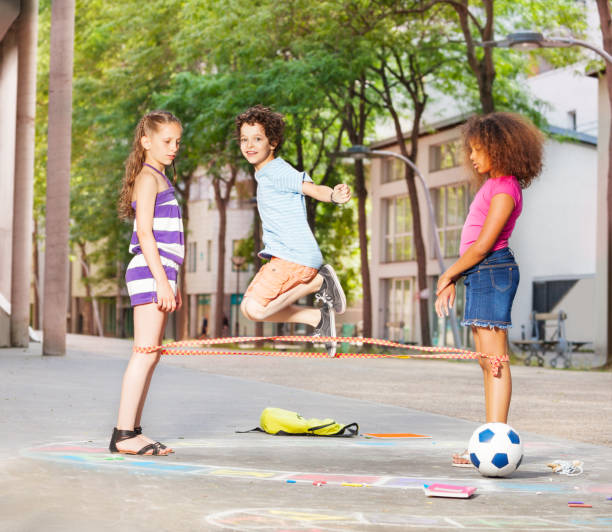 istock Boy plays elastics with friends outside 831383074