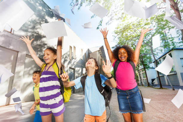 Kids throw paper in the air with sheets flying