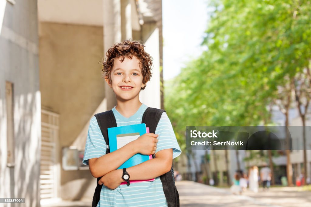 Retrato de chico guapo con los libros cerca de la escuela - Foto de stock de Francia libre de derechos