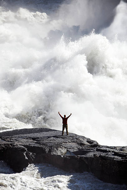man, arms raised, near bottom of waterfall - chutes virginia photos et images de collection