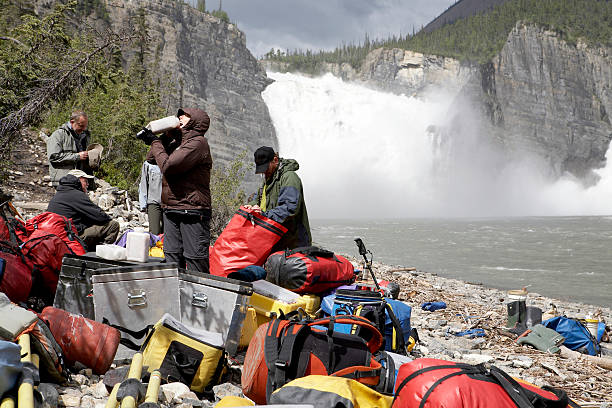 people with outdoor gear on shore near river - chutes virginia photos et images de collection