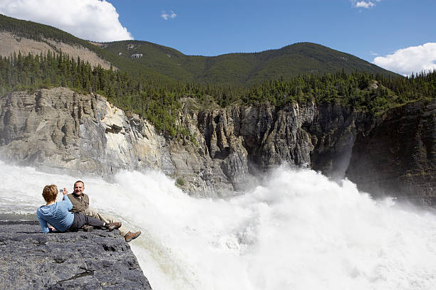 woman taking man's photo near waterfall - chutes virginia photos et images de collection