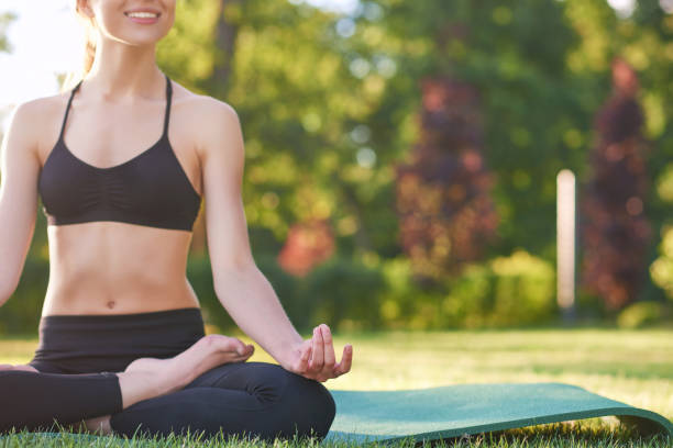 istock Young woman practicing yoga outdoors at the park 831400830