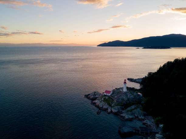 istock Atmospheric lighthouse on cliff near ocean while sunset 831408536