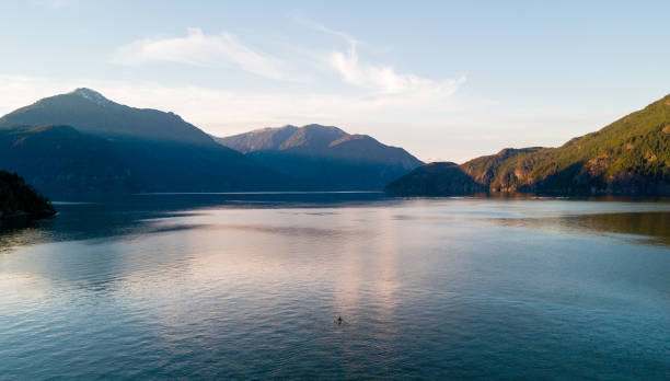 photo aérienne de baie de l’océan ou un lac avec les montagnes et le coucher du soleil - kayaking kayak sea coastline photos et images de collection