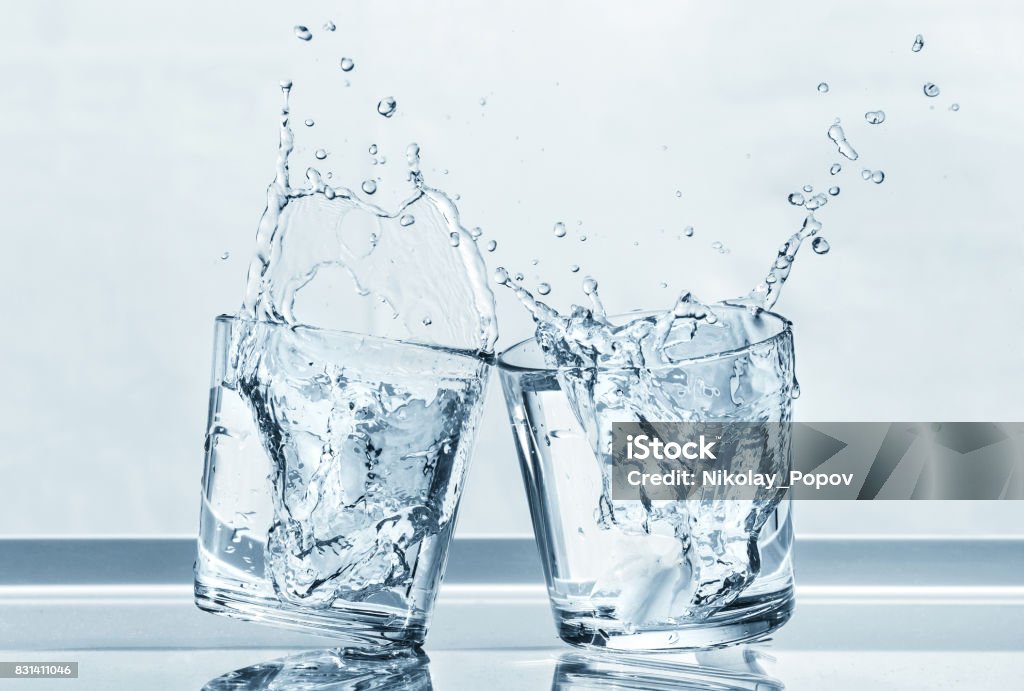 Two glasses. Clinking glasses with splashes of water. Water Stock Photo