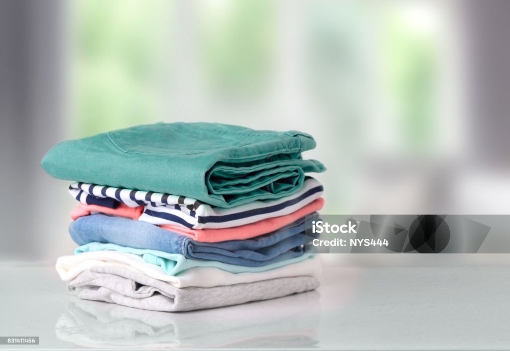 Stack colorful cotton clothes on table empty space background. Stack of clothes on table indoor.Household concept.Fresh folded cotton clothing. Clothing Stock Photo