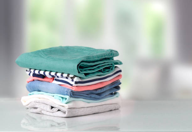 Stack colorful cotton clothes on table empty space background. Stack of clothes on table indoor.Household concept.Fresh folded cotton clothing. clothing stock pictures, royalty-free photos & images