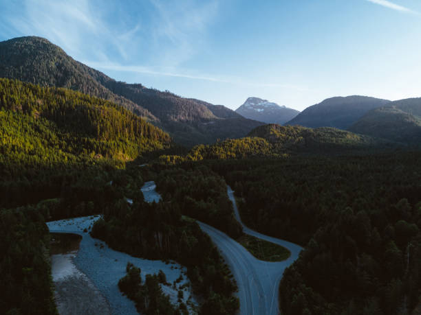 istock Aerial shot of road in valley while sunset behind mountain 831411596