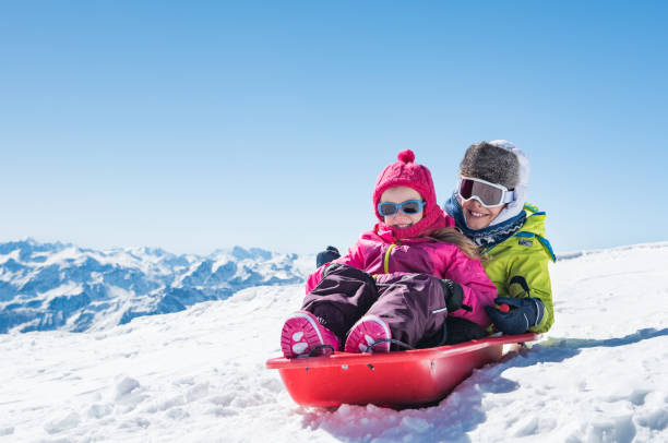 niños trineo sobre la nieve - deslizarse en trineo fotografías e imágenes de stock