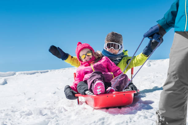 istock Father playing with children on snow 831415144