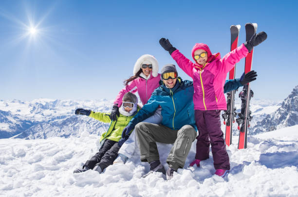 Happy family in winter holiday Laughing family in winter vacation with ski sport on snowy mountains. Happy man and woman with sons having fun and looking at camera. Family with two children enjoying winter holiday at ski resort. ski photos stock pictures, royalty-free photos & images