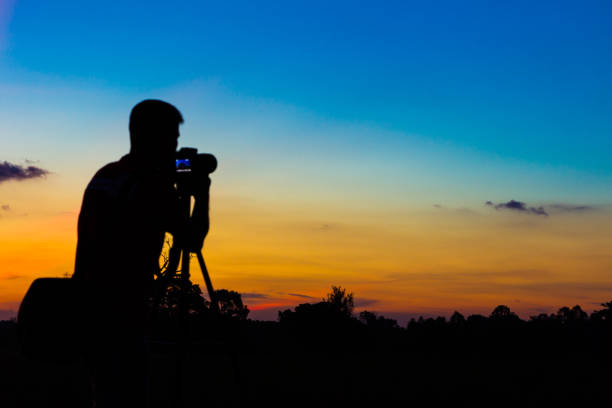 Silhouette photographer with sunset background
