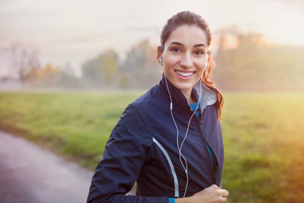 musica di ascolto runner - jogging autumn young women women foto e immagini stock