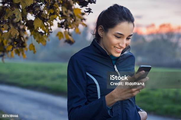 Sporty Woman Using Phone Stock Photo - Download Image Now - Using Phone, Walking, Women