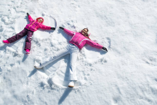 istock Daughter and mother laying on snow 831418498