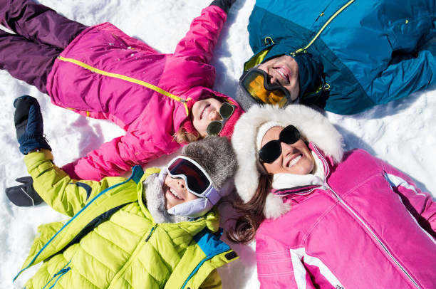 smiling family lying on snow - offspring child lying on back parent imagens e fotografias de stock