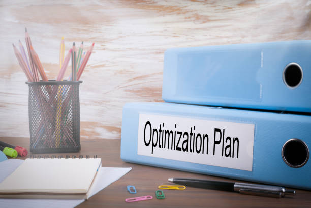 istock Optimization Plan, Office Binder on Wooden Desk. On the table colored pencils, pen, notebook paper 831418778