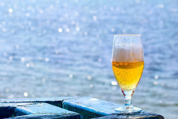 istock Goblet of beer on a table by the lake 831418988