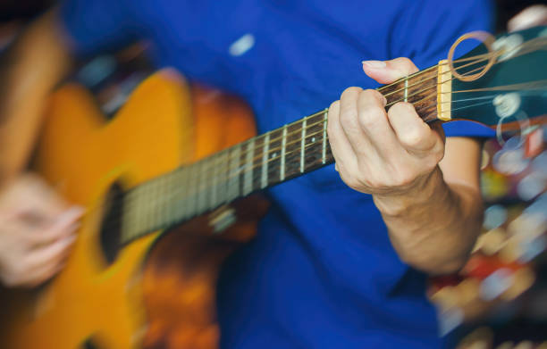 istock a man playing acoustic guitar with motion blur and bokeh background. 831419618