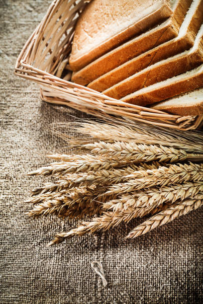 istock Wicker basket sliced bread rye ears on burlap background 831423314