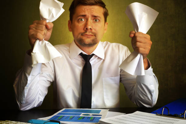 istock Nervous businessman observing bills. Problems in a business. 831426230
