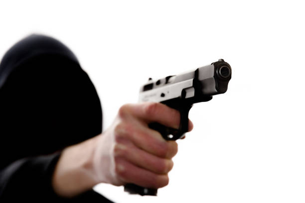 Unrecognizable man in hoodie with handgun
