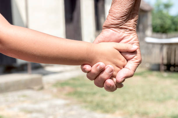 The hands of an elderly couple holding each other close
