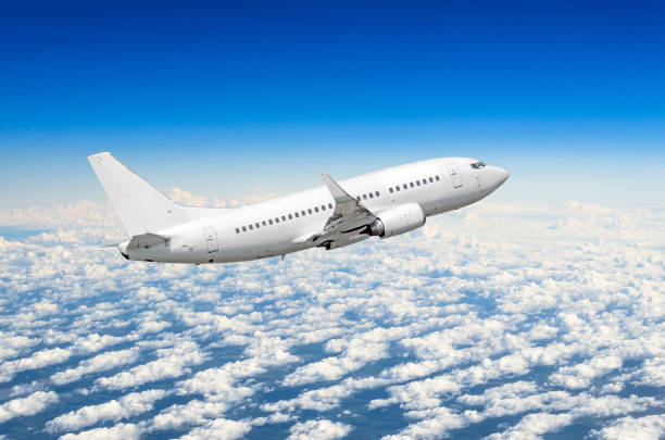 istock White airplane flies high in the sky above the clouds blue sky 831434734