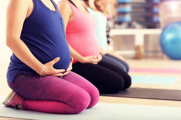 gruppe von schwangeren während fitness-klasse - relaxation exercise child mother human pregnancy stock-fotos und bilder