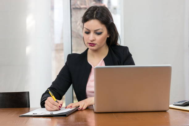 istock Businesswoman writing in her notebook planning something. 831453306