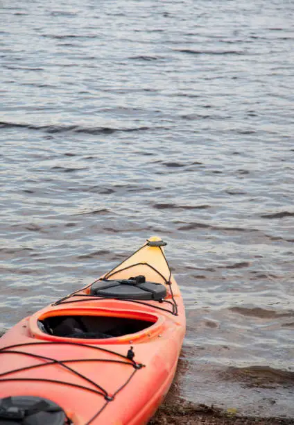 an orange and yellow kayak in the lake with copy space, vertical