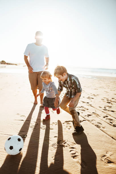 istock happy family playing soccer on the beach 831477672