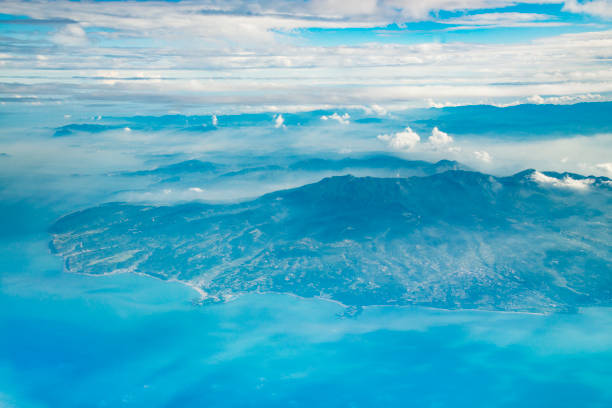 The city of Taipei, the capital of Taiwan, seen from an airplane during the afternoon. Some fog hanging over the city.
