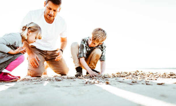 istock family playing with the sand on the beach 831484182