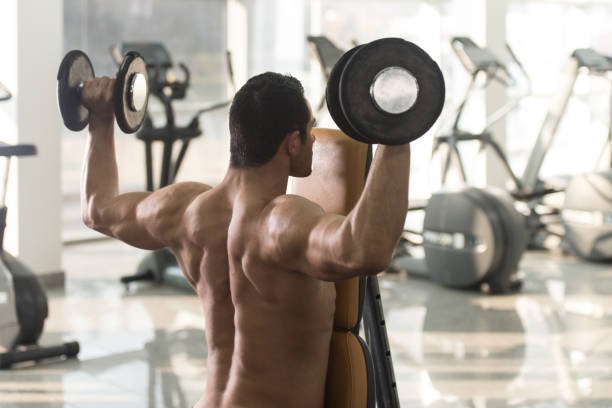 istock Shoulders Exercise With Dumbbells In A Gym 831487818