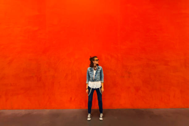Woman walking in front of red background