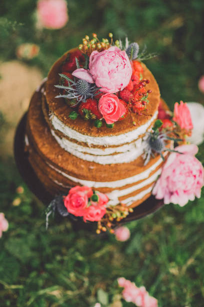 istock Beautiful wedding cake with flowers, outdoors. two levels 831506290