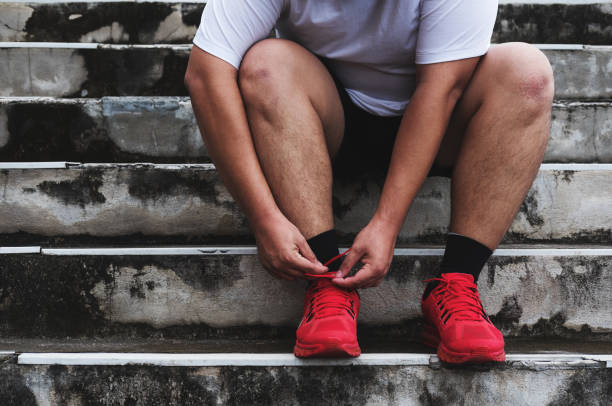 ragazzo asiatico che lega la scarpa da corsa, si prepara a correre per perdere peso - weight scale dieting weight loss foto e immagini stock